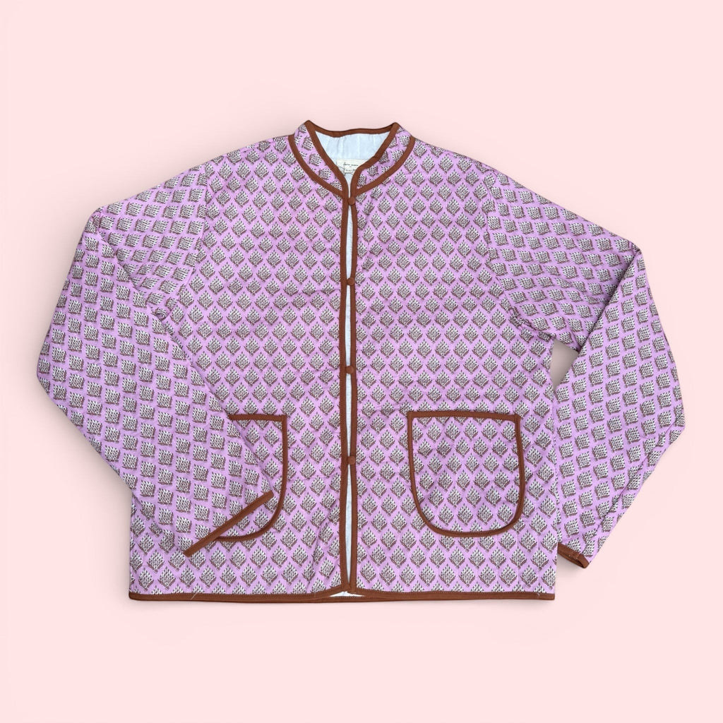 The Marley Edit pink quilted jacket with block print, round neck, button front, and tan binding. Lightweight and lined.