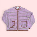 The Marley Edit pink quilted jacket with block print, round neck, button front, and tan binding. Lightweight and lined.